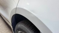A scuffed wheel arch, easy to miss on a standing walk-round but obvious once you crouch down to look along the panel.