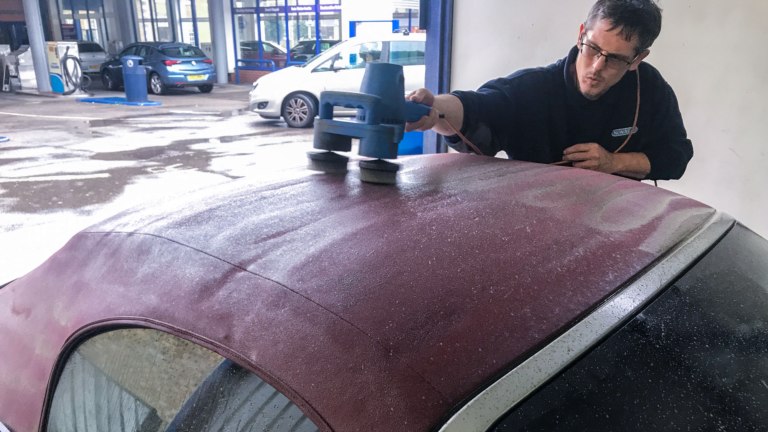 Cleaning a soft top roof with a mechanical brush.