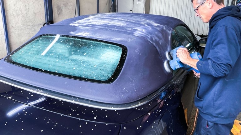 James cleaning a soft top roof with a mechanical brush in our wash bay