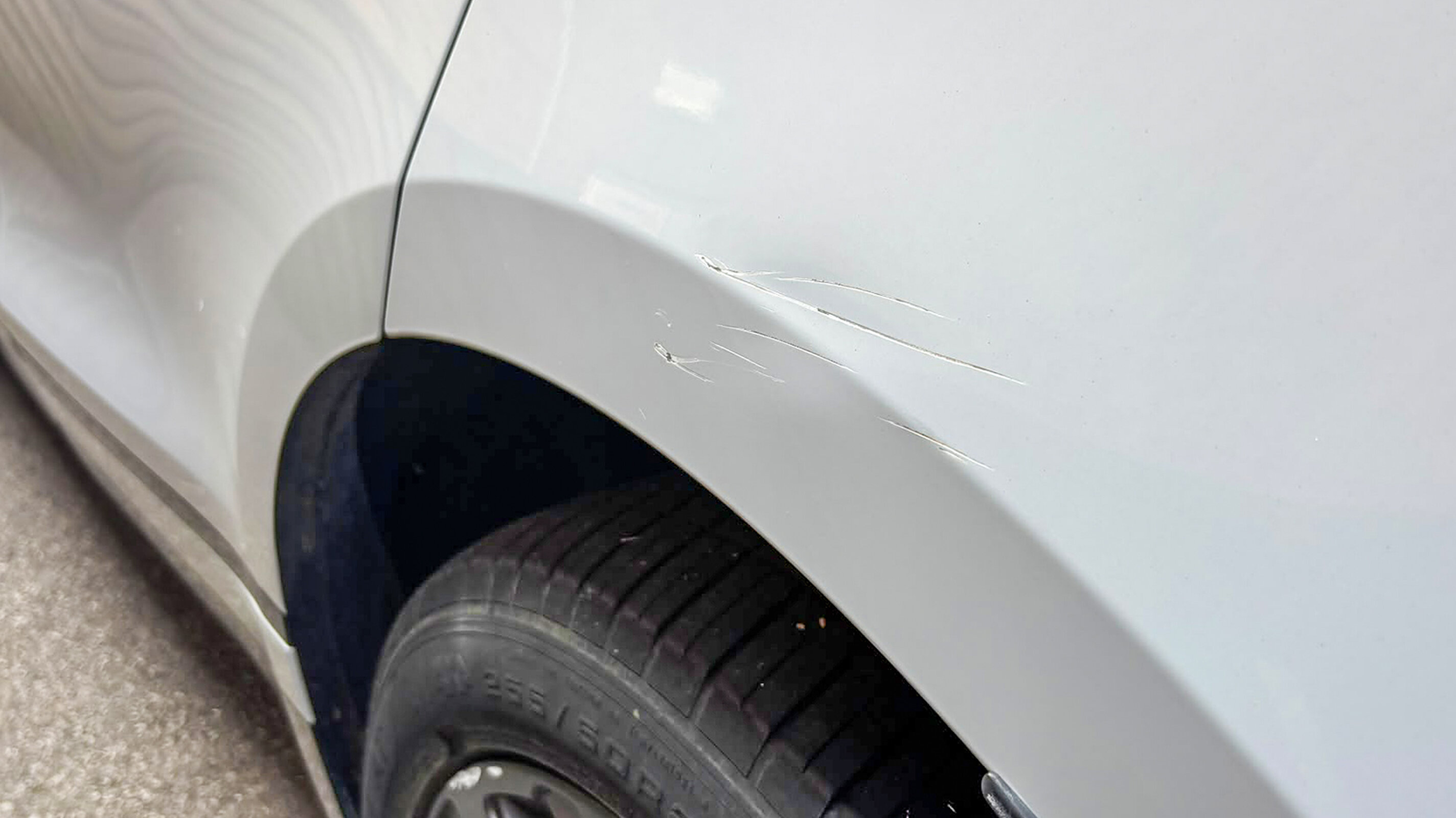 A scuffed wheel arch, easy to miss on a standing walk-round but obvious once you crouch down to look along the panel.