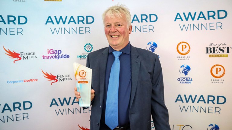 Gary Wray holding the Prestige Awards winner trophy at the awards ceremony