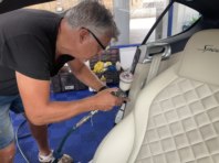 Allan works on the seat of a Bentley.