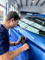 Alfie using a small buffer to polish a scratch from a BMW