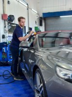 Tom drying a recently cleaned fabric roof of a convertible Jaguar.