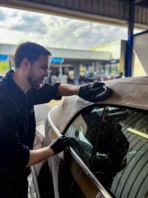 Tom scrubbing a cabriolet roof with a brush.