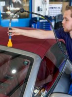 Tom uses an air blade to push water out of the cabriolet hood.