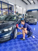 Alfie detailing a car, polishing up the coating.