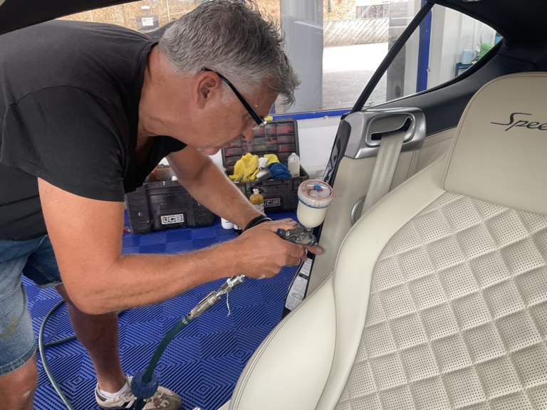 Alan recolouring the cream leather on a damaged seat at the New Again workshop