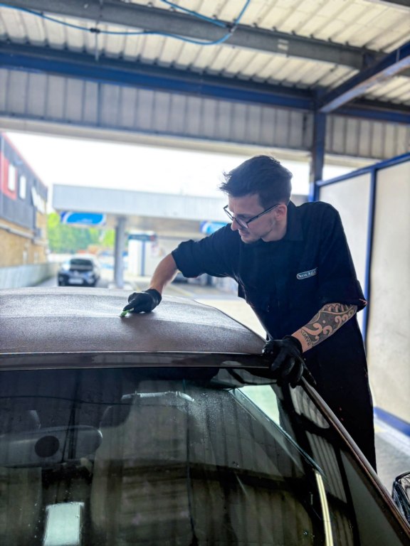 Matt cleaning convertible roof stitching with a small brush in the New Again wash bay
